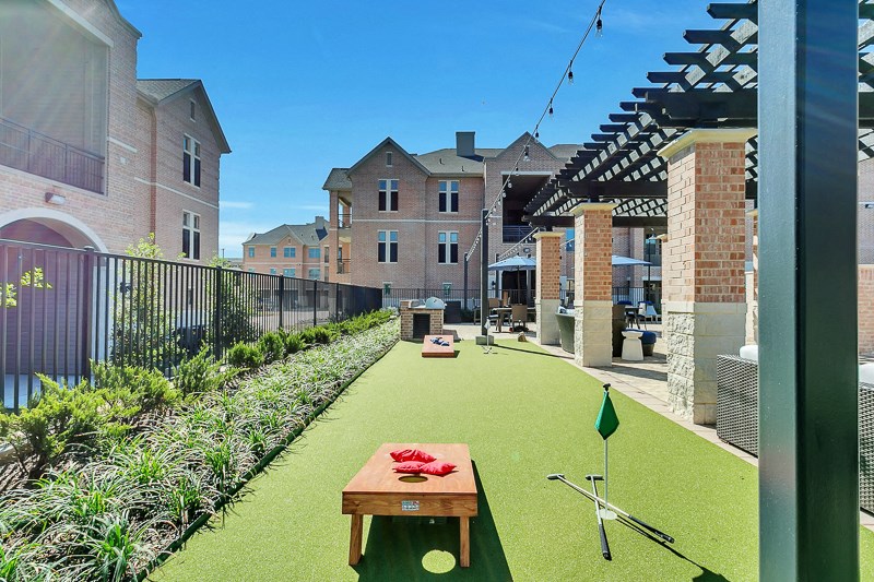 a communal area with a putting green and a table with a racket