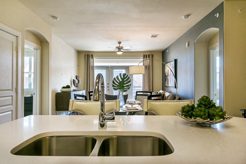 a kitchen with a sink and a view of a living room