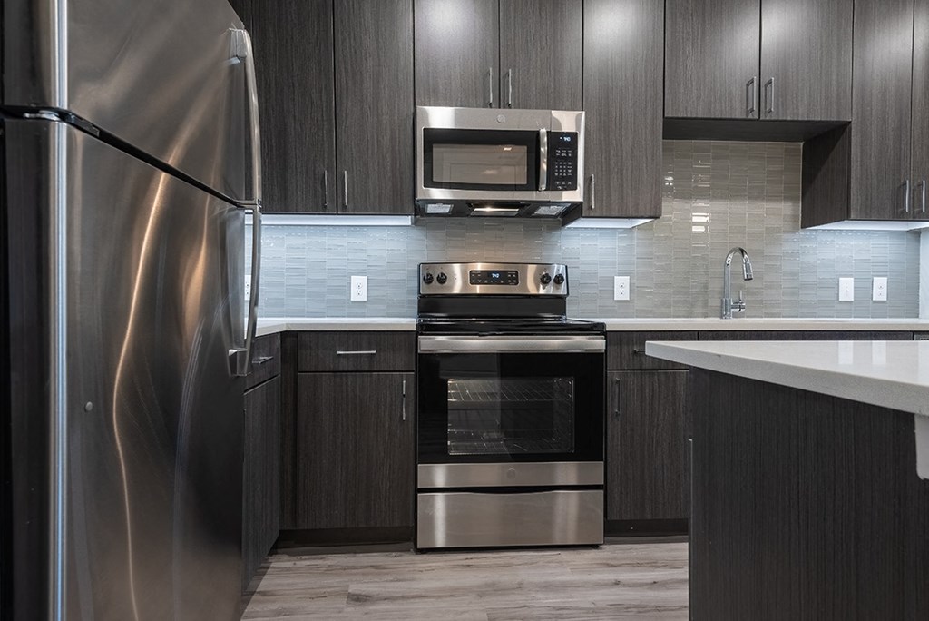 a kitchen with stainless steel appliances and dark wood cabinets