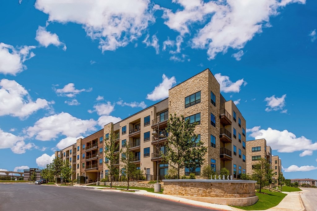 a large apartment building with a street in front of it