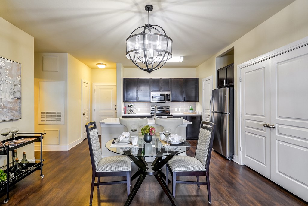 a kitchen and dining room with a glass table and chairs