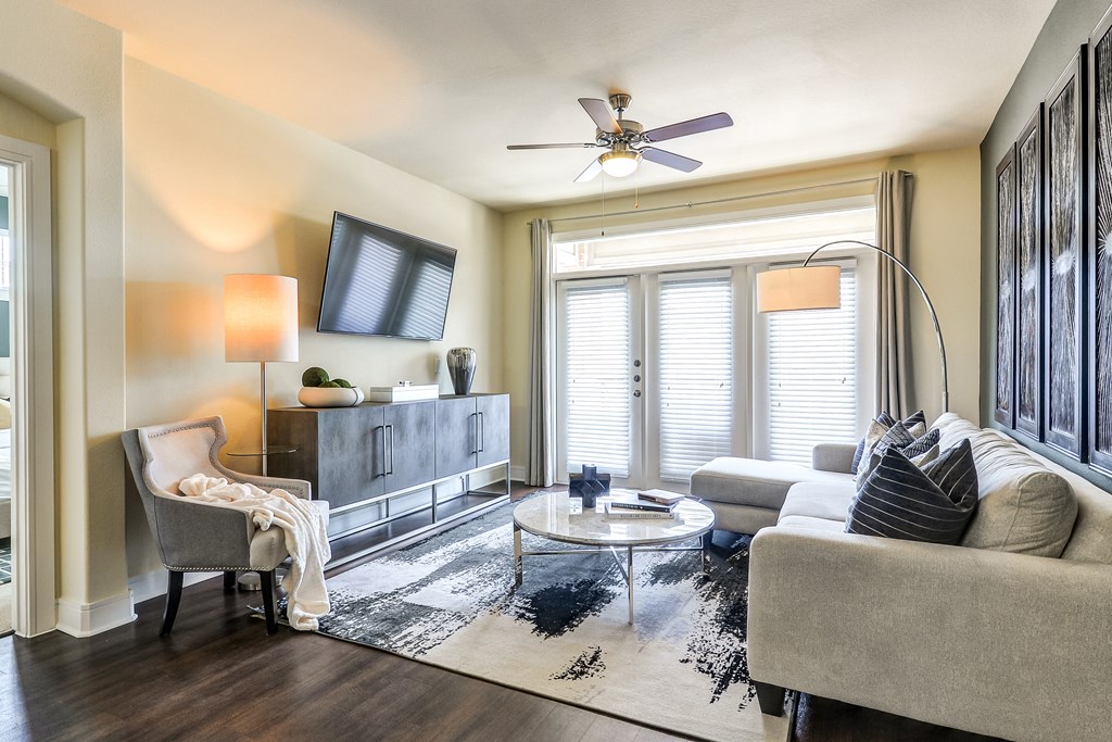 a living room with a large window and a ceiling fan