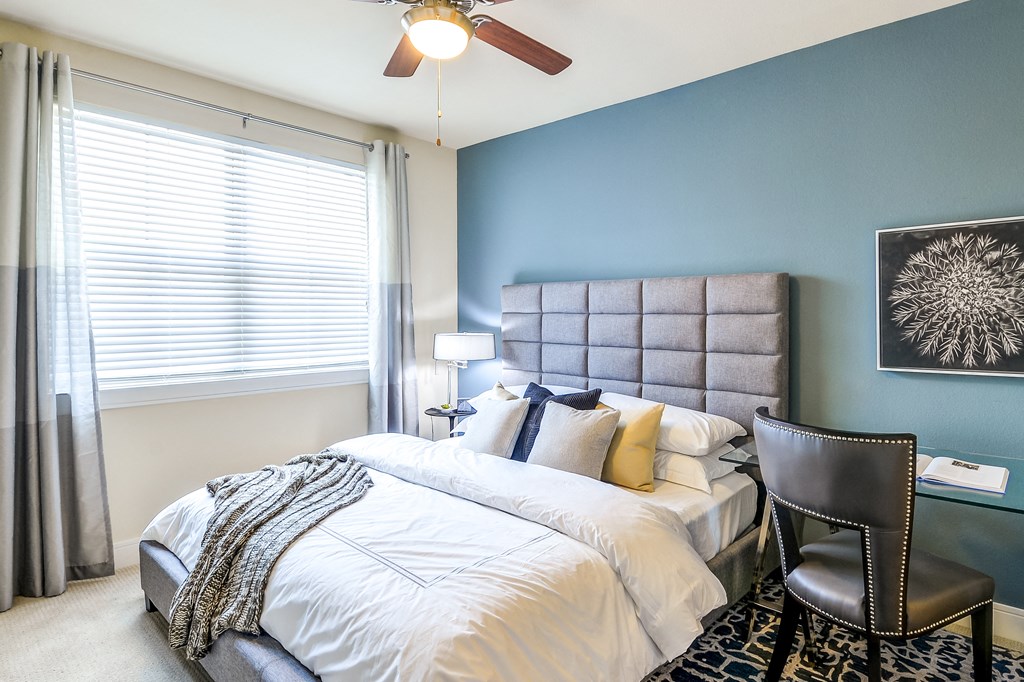 a bedroom with a large bed and a ceiling fan