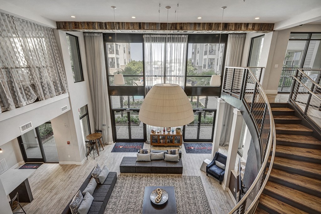 a view of the living room from the second floor of an apartment with a staircase