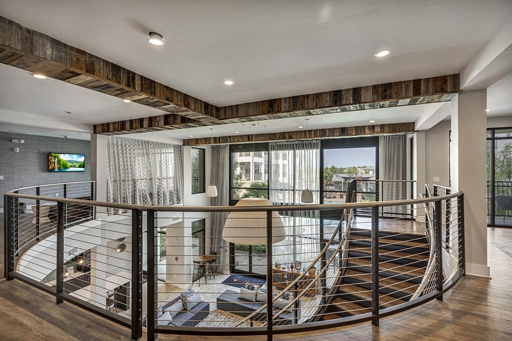 a spiral staircase leading to a living room and a balcony
