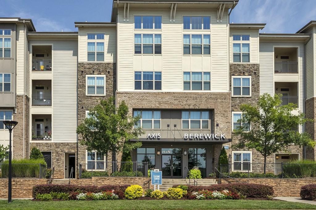 an exterior view of an apartment building with a lawn