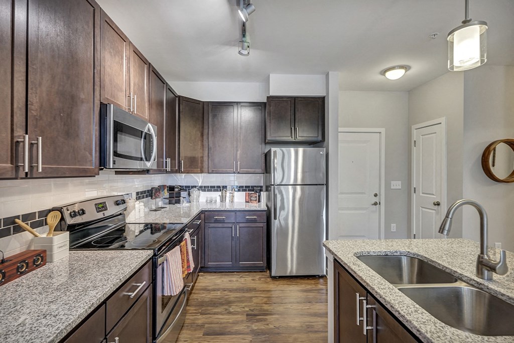 an updated kitchen with stainless steel appliances and granite counter tops