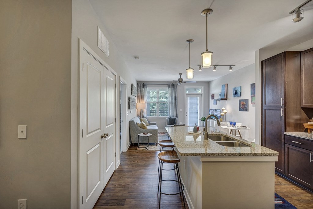 an open kitchen and living room with an island and stools
