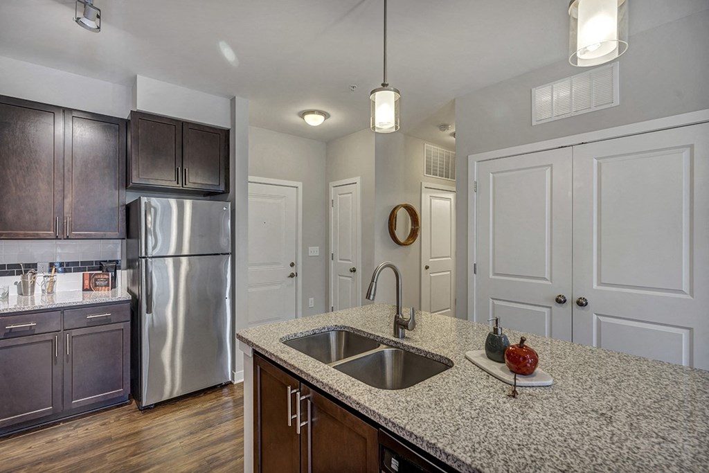 a kitchen with a sink and a stainless steel refrigerator