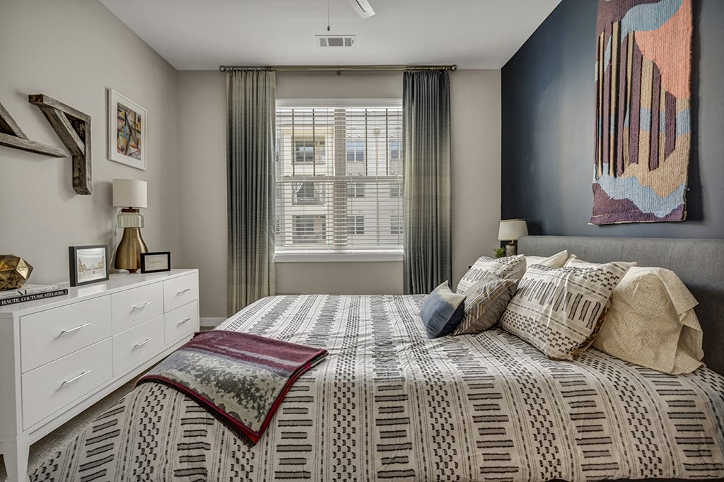 a bedroom with a bed and a large window