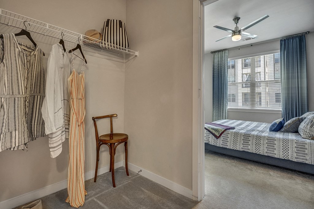 a bedroom with a closet and a bed and a ceiling fan