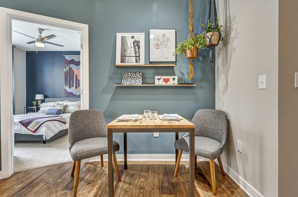 a dining room with a table and two chairs and a bedroom with a bed