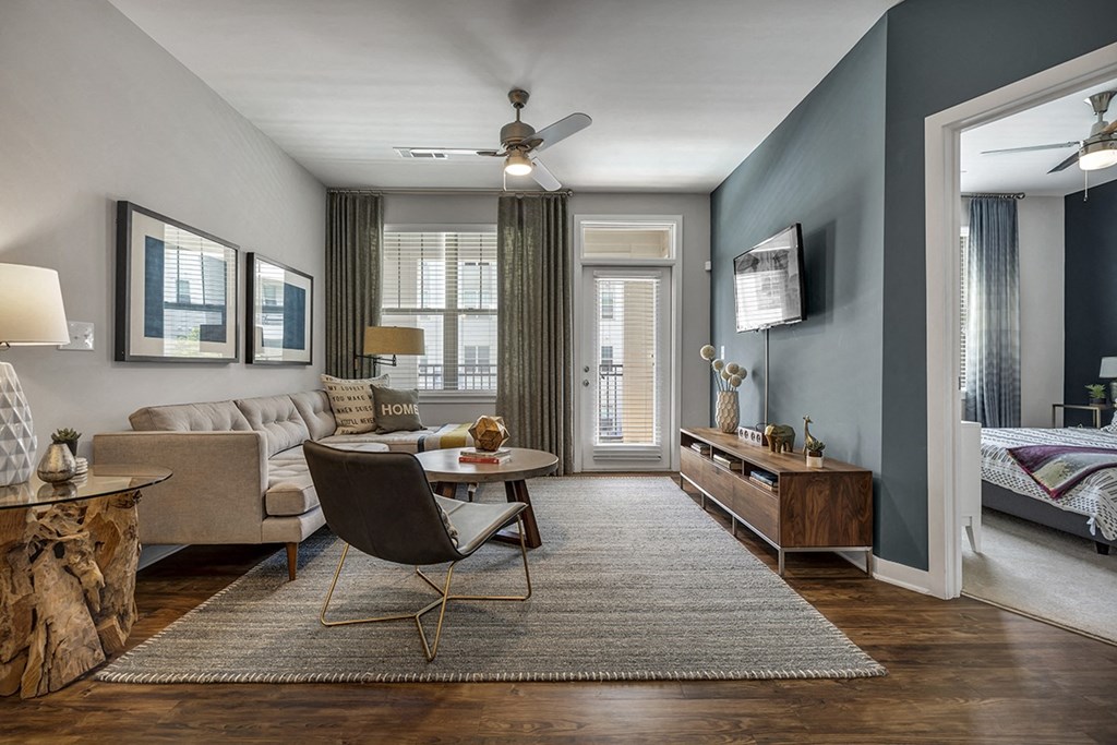 a living room with blue walls and a ceiling fan