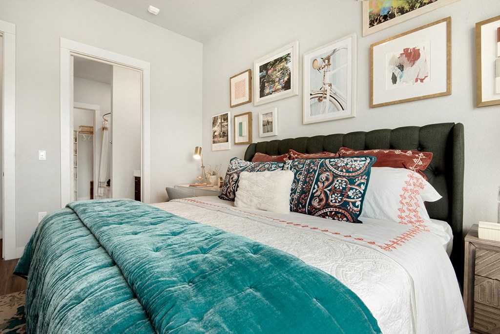 a bedroom with a bed and pictures on the wall