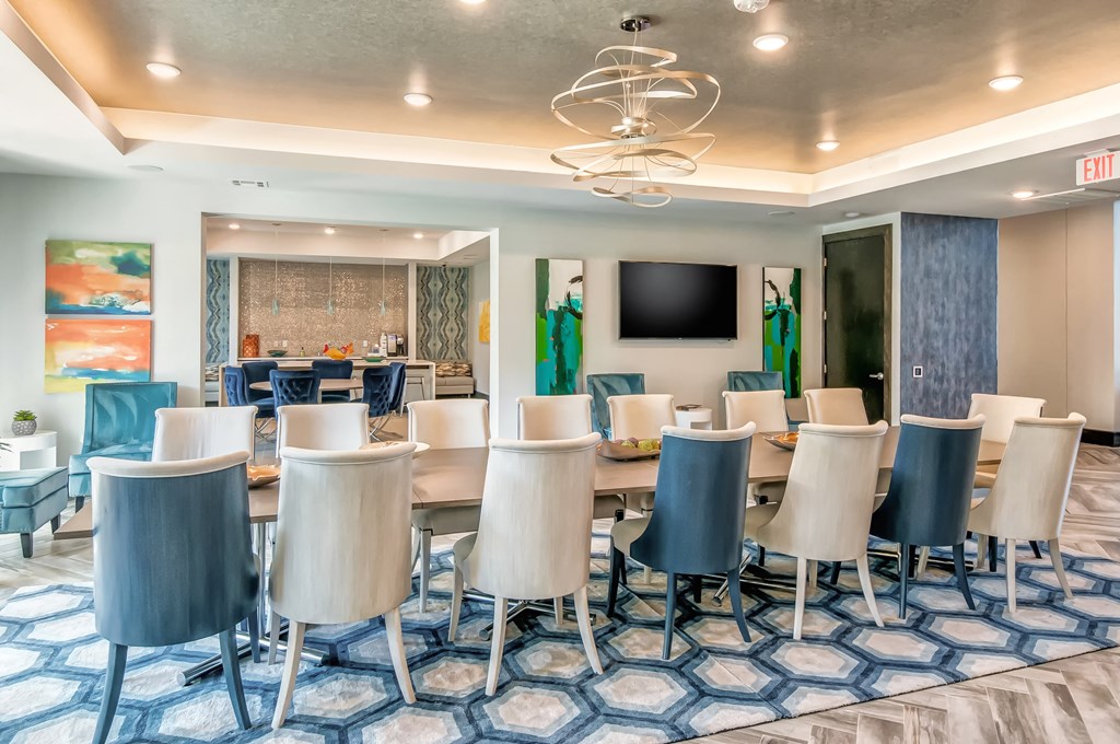 a conference room with a long table and chairs and a tv