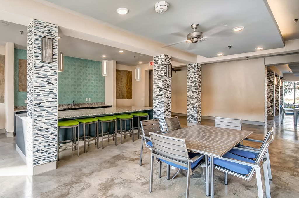a dining area with a table and chairs and a bar