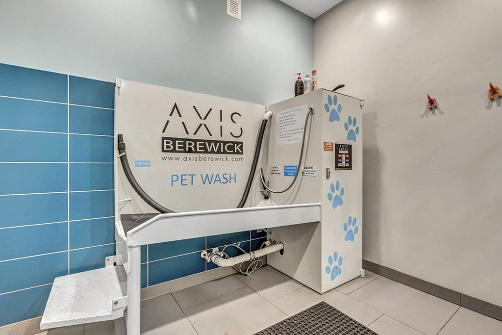 a washing machine in a restroom with a urinal and a sink