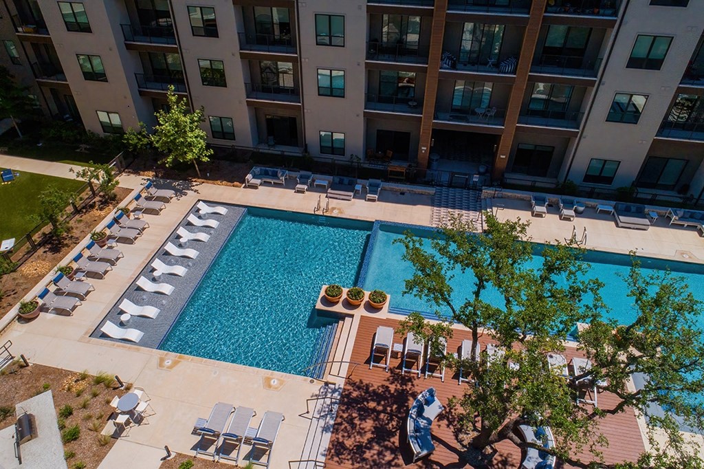 an aerial view of a swimming pool in front of an apartment building