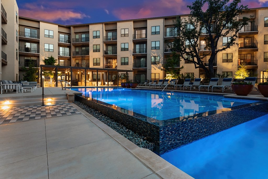 a swimming pool with an apartment building in the background