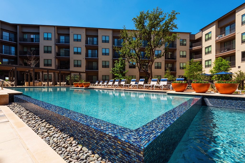 a swimming pool with an apartment building in the background