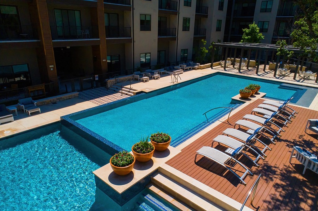 a pool with lounge chairs and a swimming pool