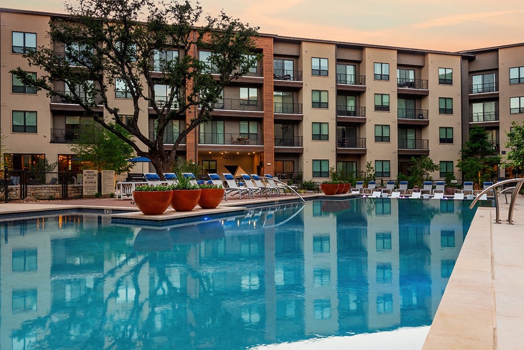 a swimming pool with an apartment building in the background