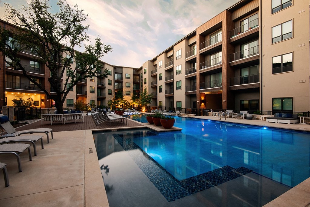 an apartment swimming pool in front of an apartment building