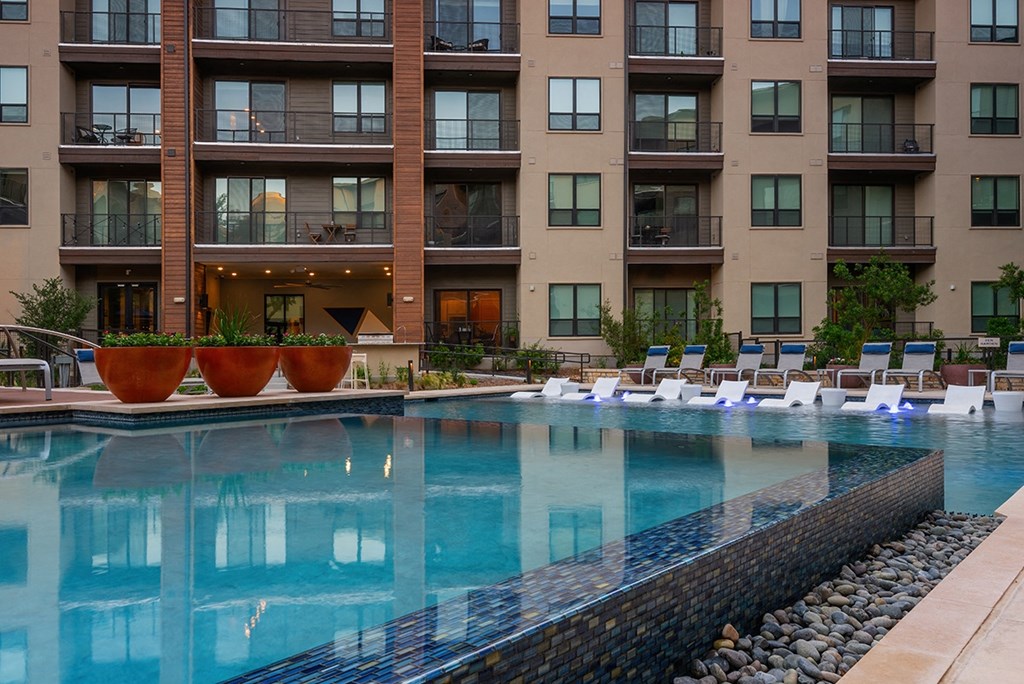 a swimming pool in front of an apartment building