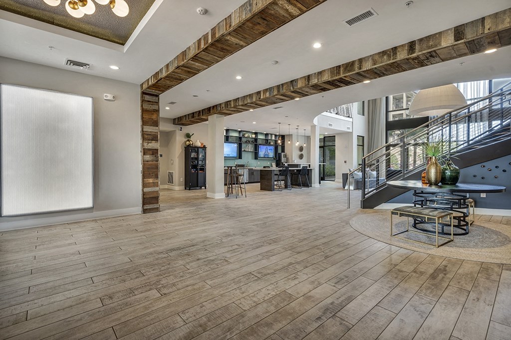 the lobby of a building with a staircase and wood floors
