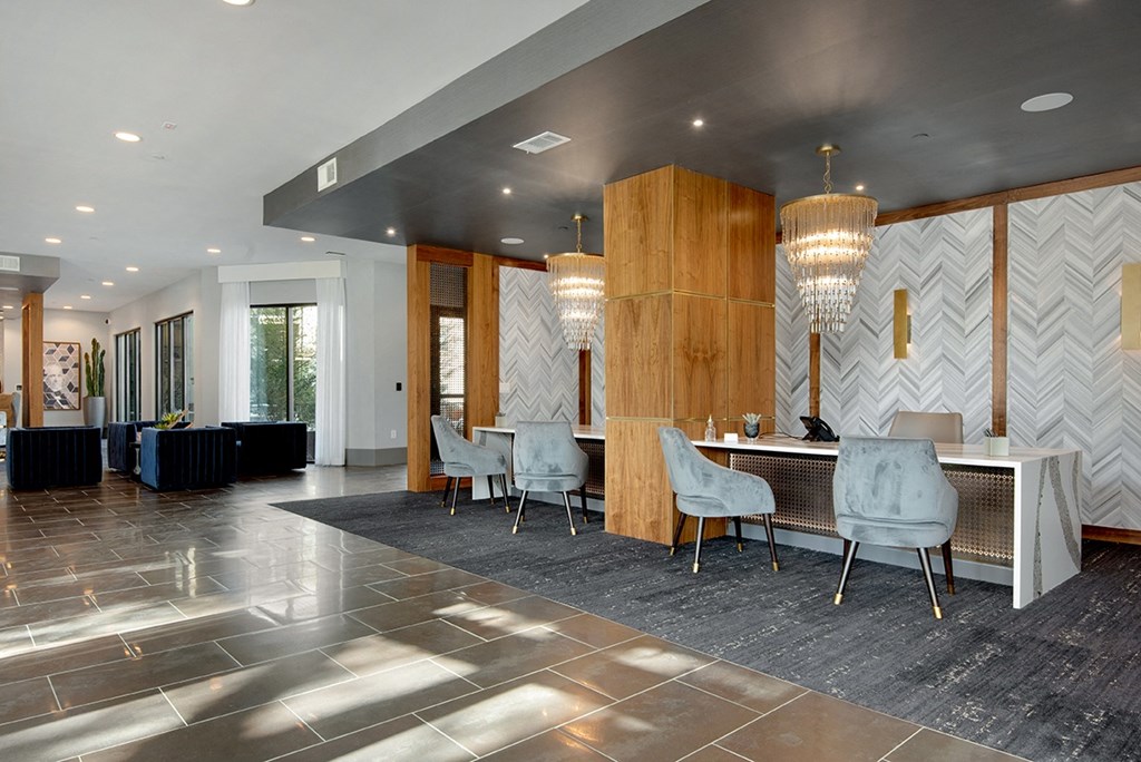 a large lobby with a table and chairs and chandeliers