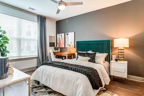 A bedroom with a white bed and a green headboard.