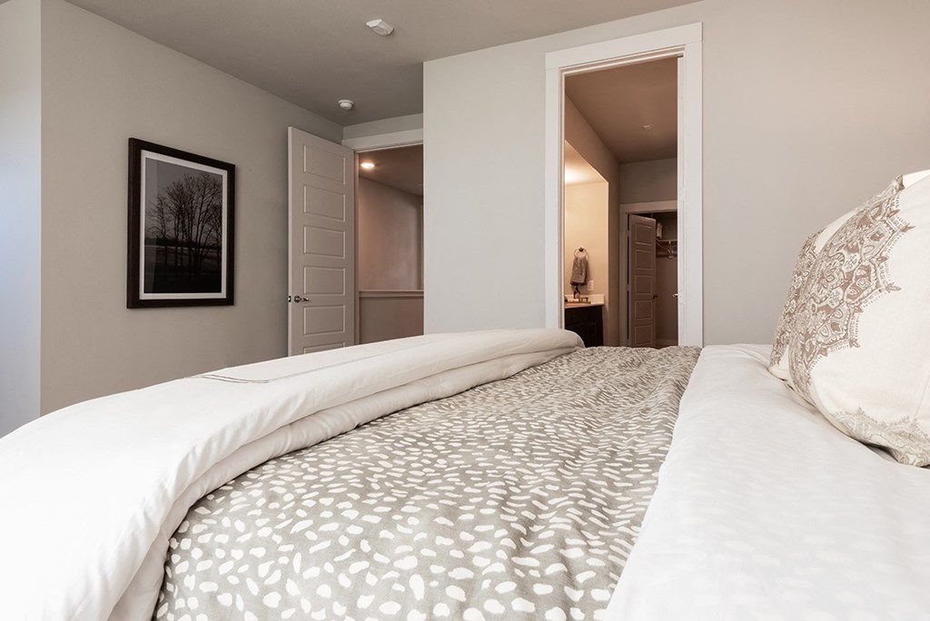 a bedroom with a large bed and a door to a bathroom