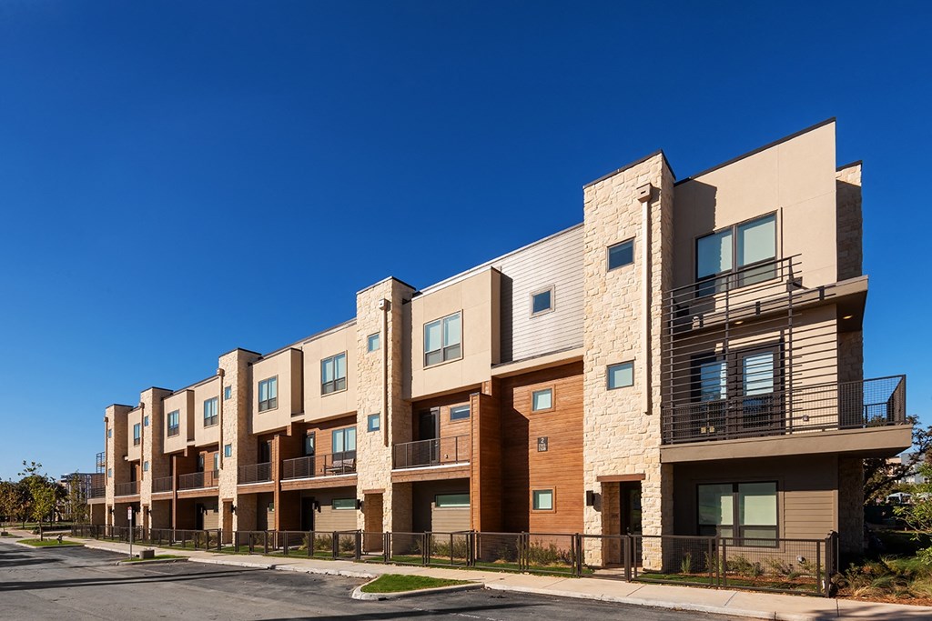 a row of apartment buildings with balconies and a blue sky