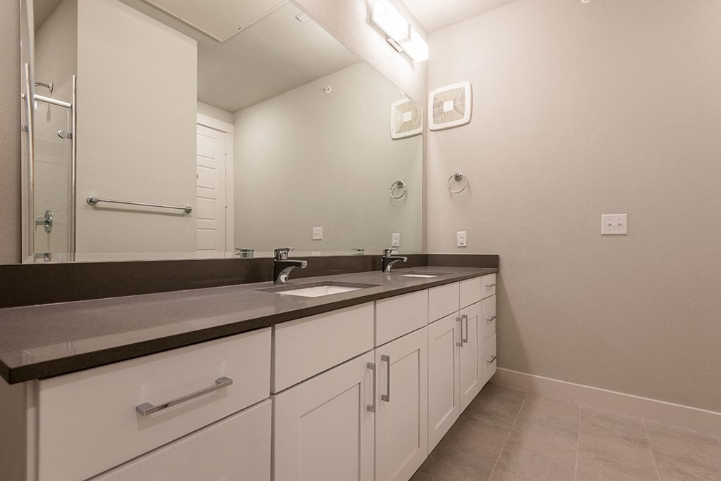 a bathroom with two sinks and a large mirror
