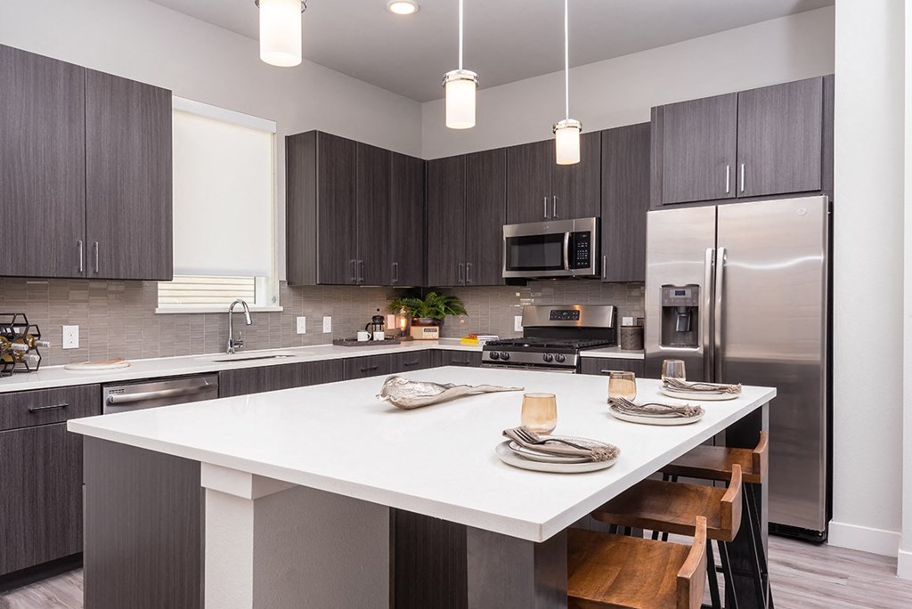 a kitchen with a large island and stainless steel appliances