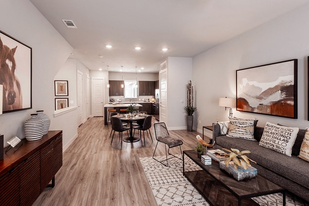 a living room with a couch and a table in front of a kitchen