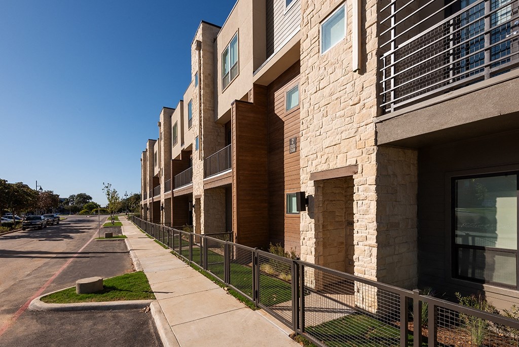 a row of apartment buildings on the side of a street