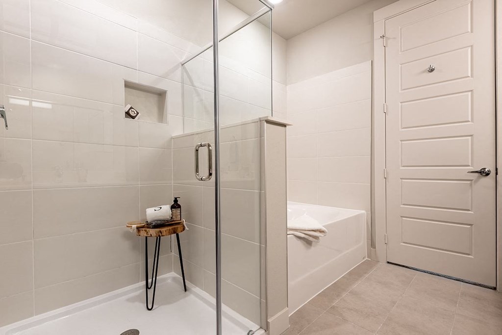 a white bathroom with a shower and a tub