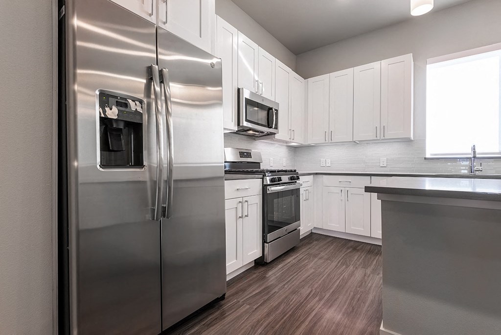 a kitchen with stainless steel appliances and white cabinets