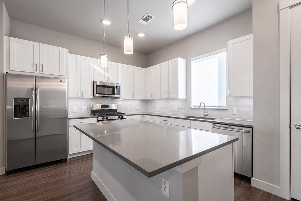 a kitchen with an island and stainless steel appliances