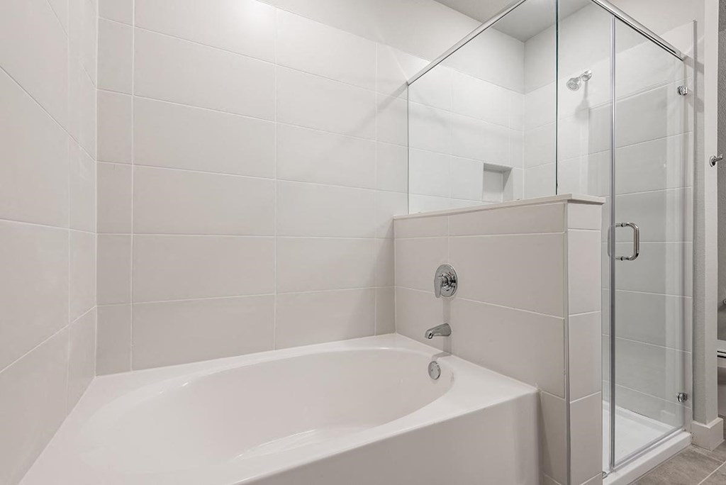a white bathroom with a shower and a tub