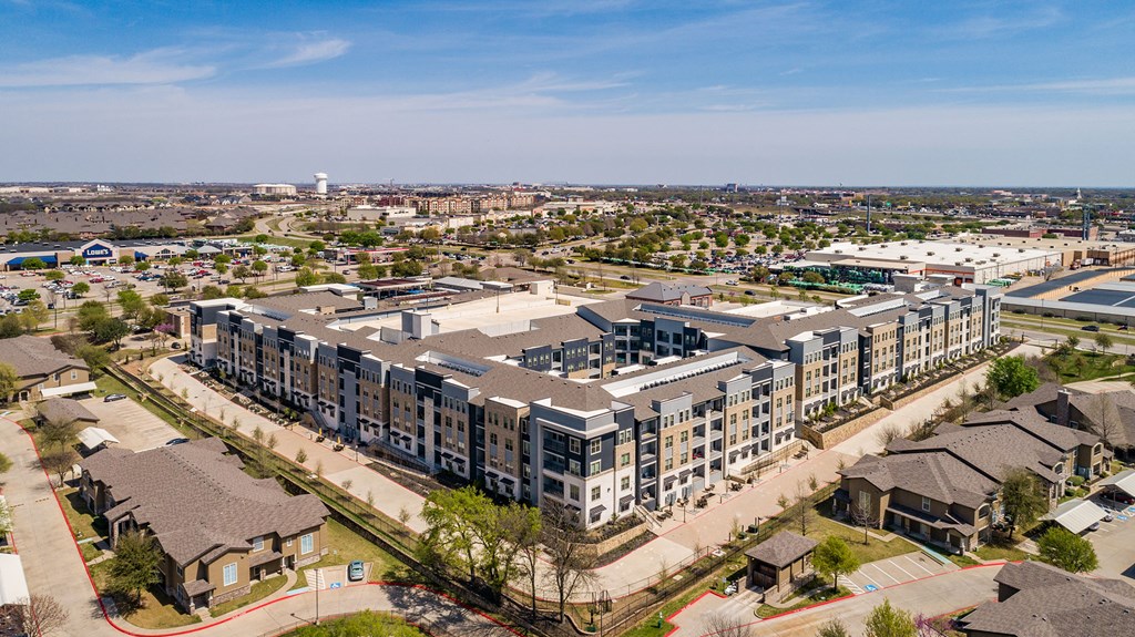 an aerial view of a large apartment complex with a city in the background