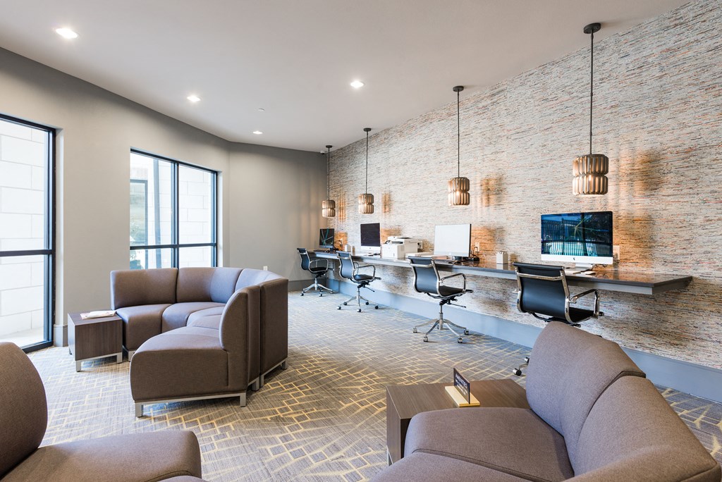 a room with couches chairs and a desk with a computer