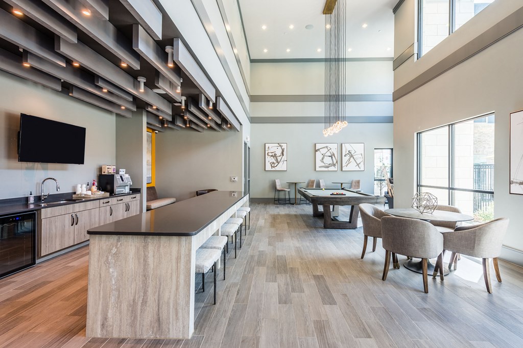 a communal area with tables and chairs and a kitchenette