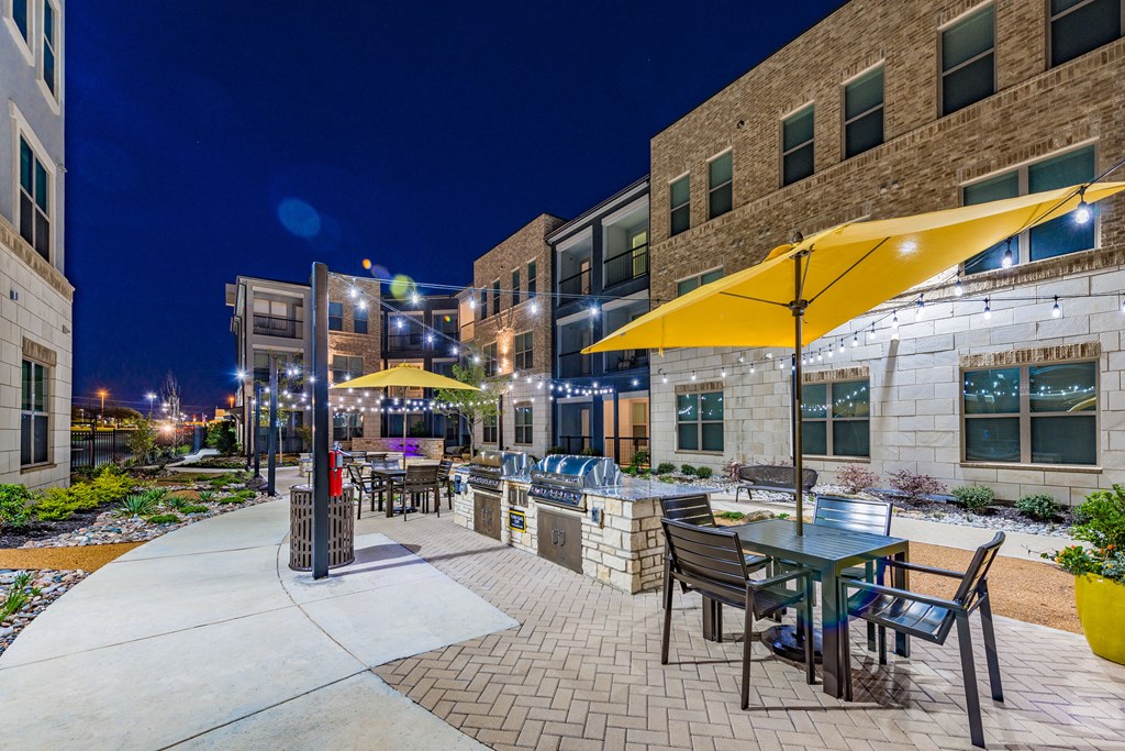 a patio with yellow umbrellas at night