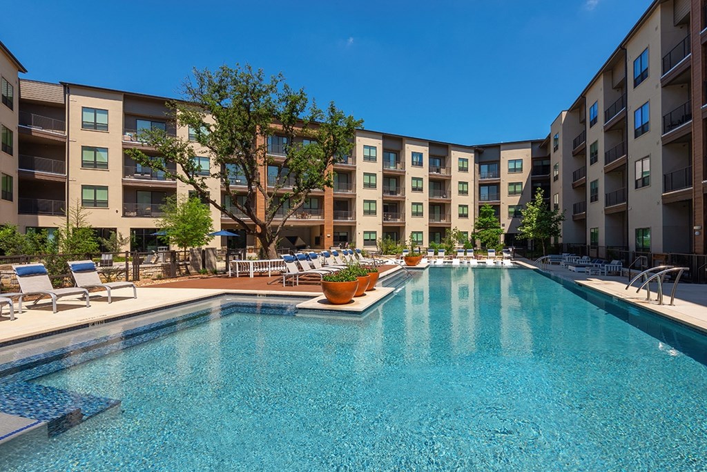 a swimming pool with an apartment building in the background