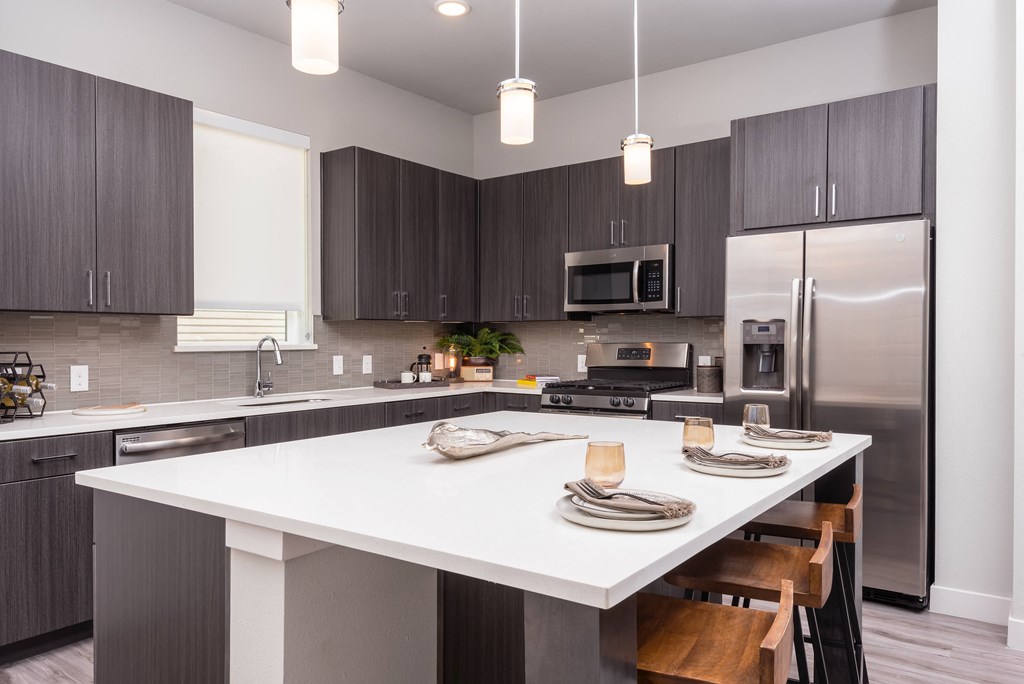an open kitchen with a large island and stainless steel appliances