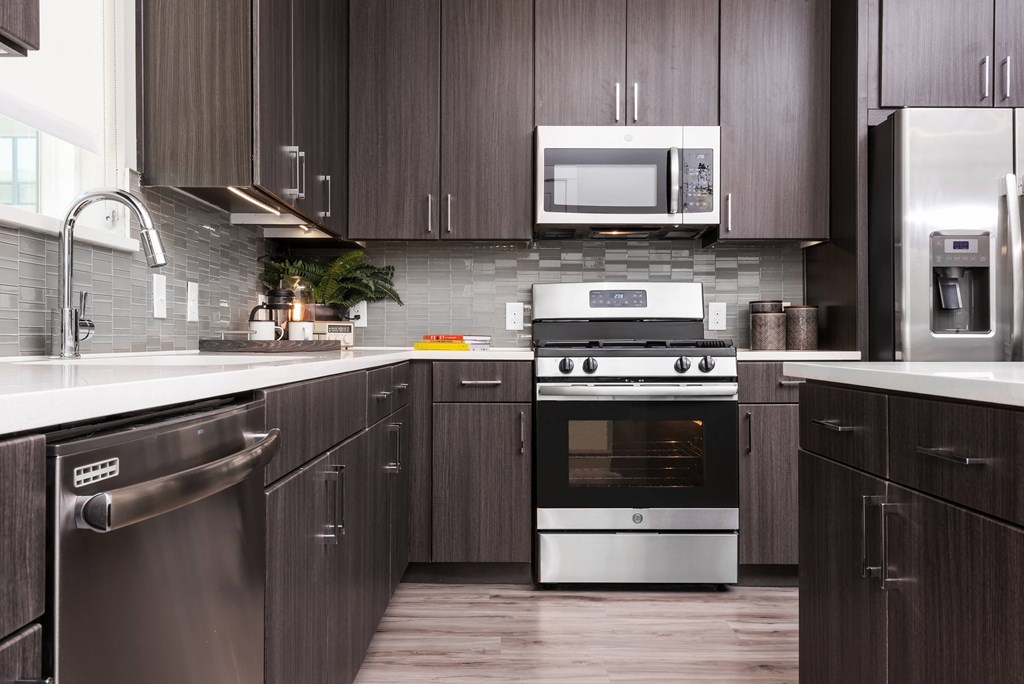 a kitchen with stainless steel appliances and dark wood cabinets