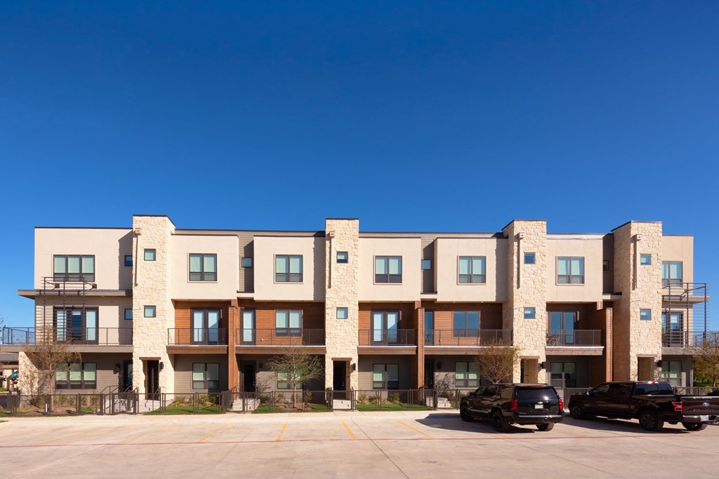 an apartment building with cars parked in front of it