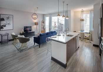 a kitchen and living room with a white counter top in an open floor plan